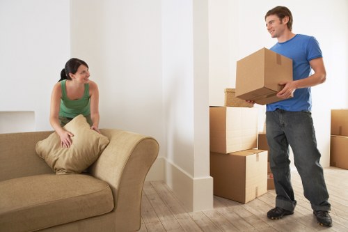 Professional movers carrying furniture through a Balham property